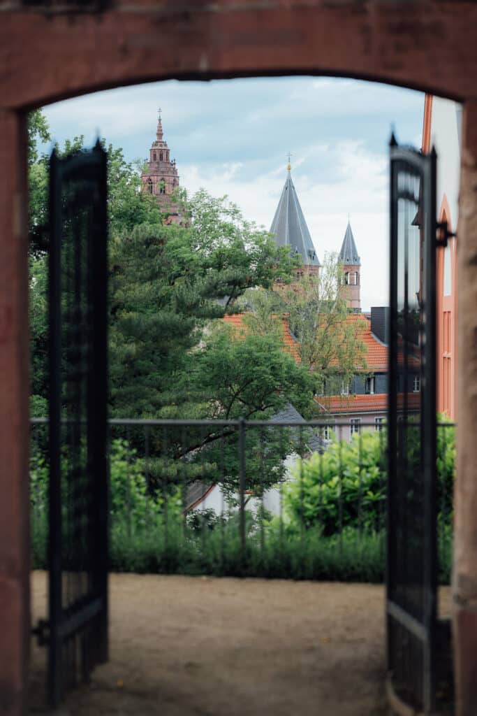 Blick durch ein geöffnetes Gartentor auf den Dom zu Mainz 