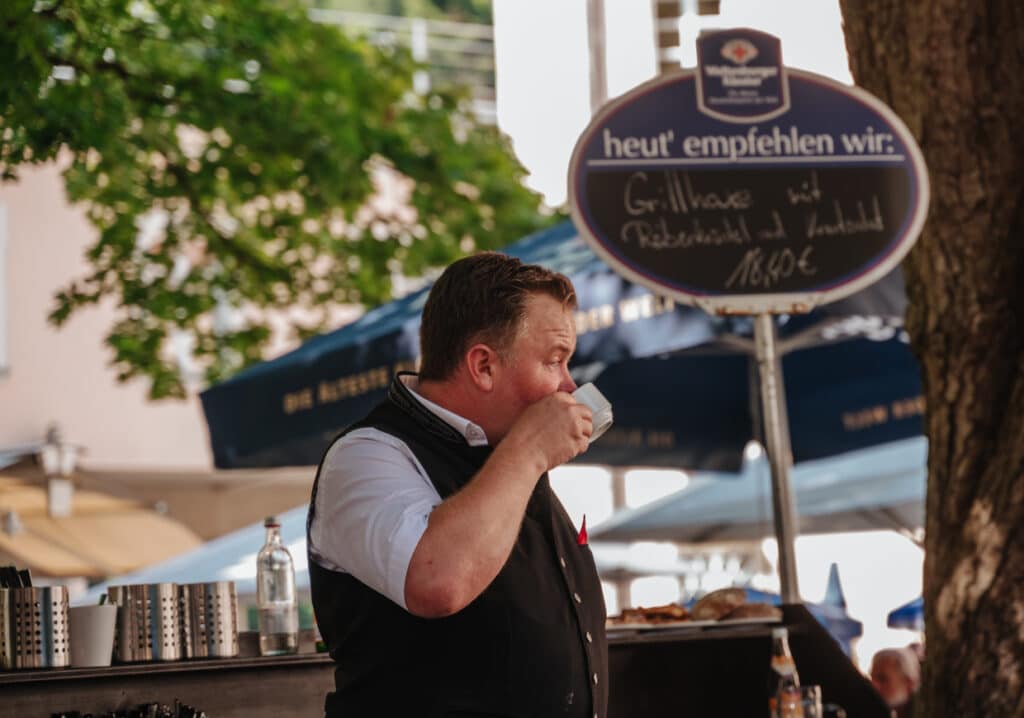 Eine Bedienung im BIergarten trinkt Kaffee während einer Pause